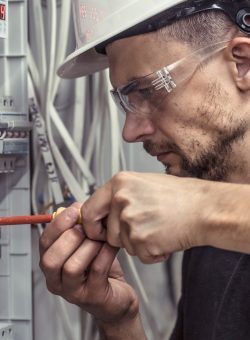 a-male-electrician-works-in-a-switchboard-with-an-electrical-connecting-cable.jpg